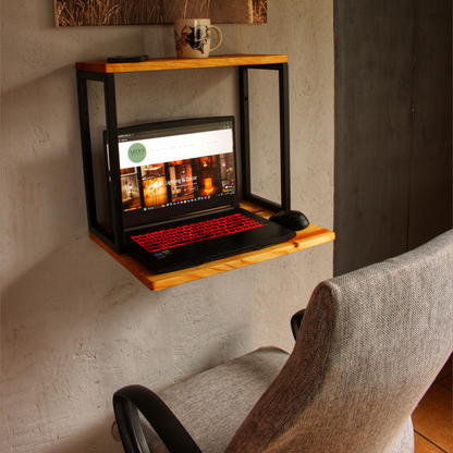 A wall-mounted workstation with a laptop on it, featuring a red and black color scheme with a natural pine top and matt black metal frame.