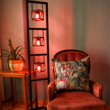 Modern floor lamp with 3 lights next to a classic chair with pot plant next to it