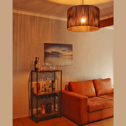A bar cart with various liquor bottles in a lounge next to a leather couch