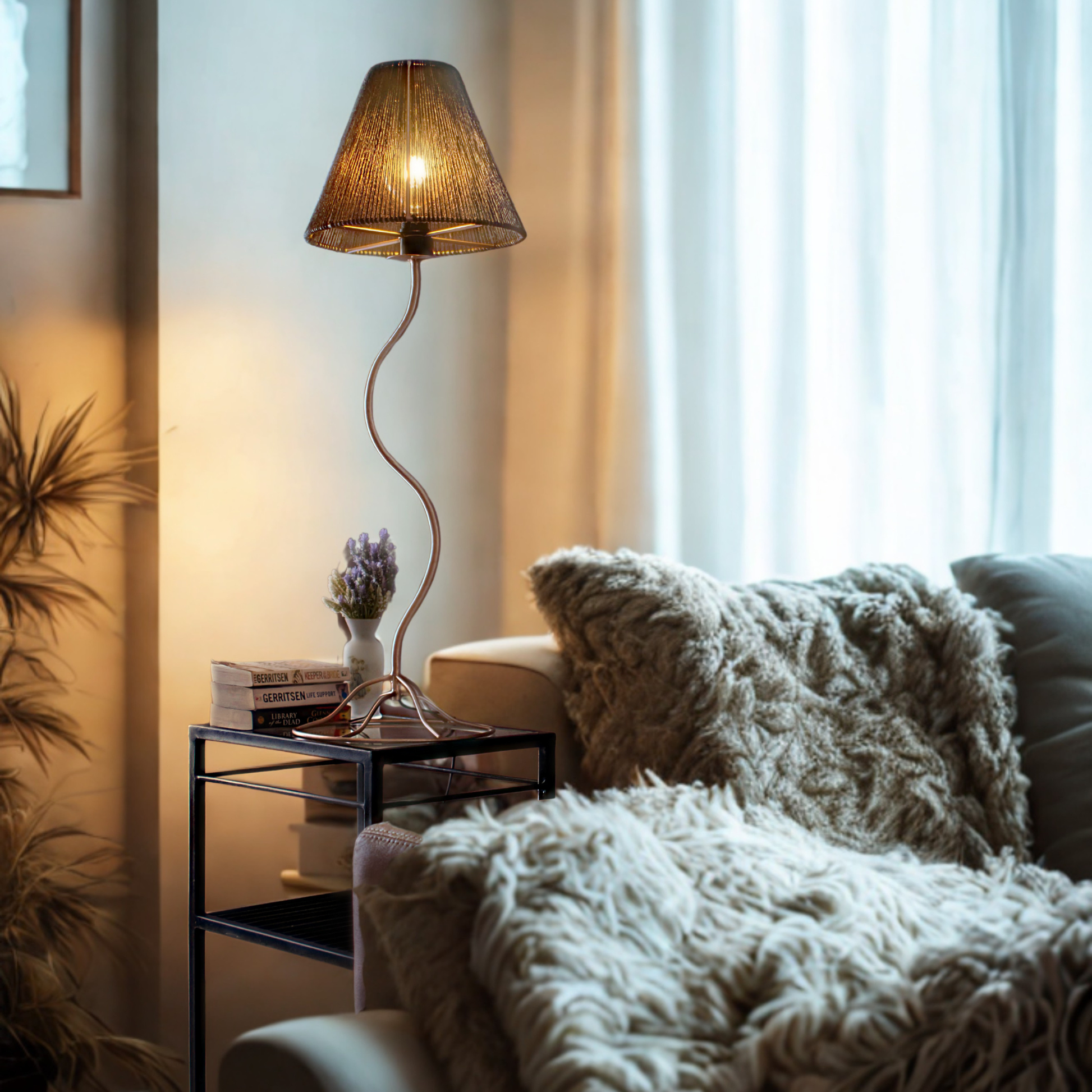 Bespoke table lamp on a metal and glass table next  to a luxurious couch with natural light through curtains 