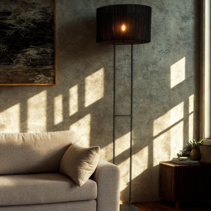 Living room with a beige sofa, floor lamp, and abstract painting on a textured wall.